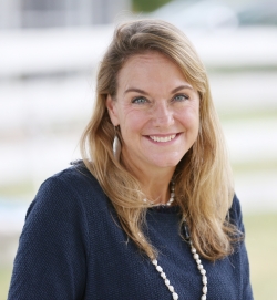 Cabell is smiling at the camera. 