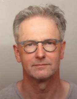 Joop Mekke is smiling at the camera. The photo is a head shot. 